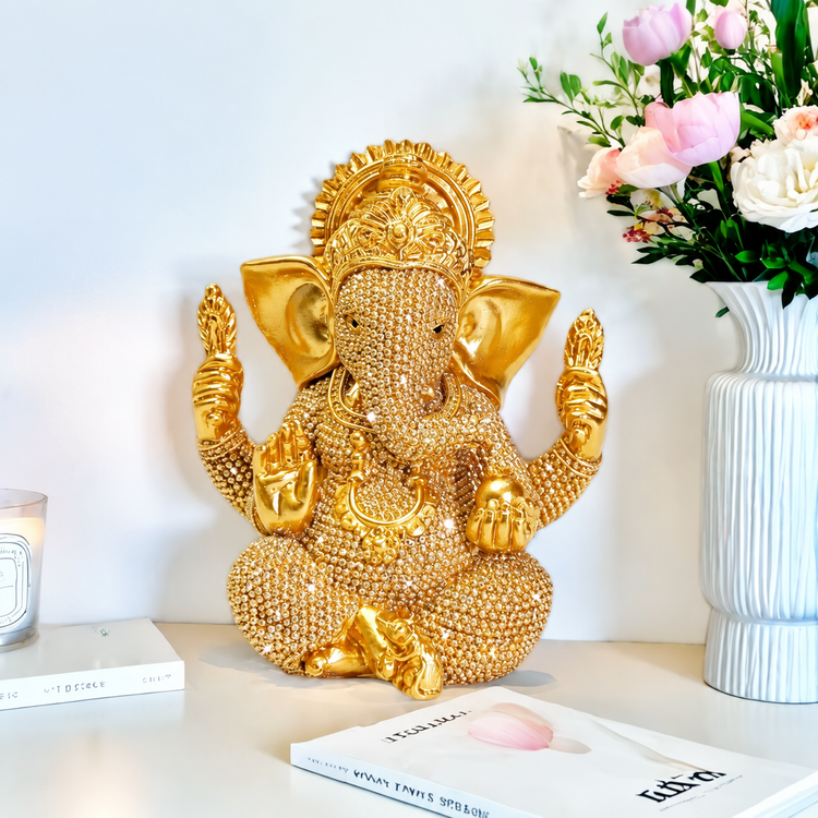 Gold-tone seated Ganesha idol with beaded surface detail in a light interior
